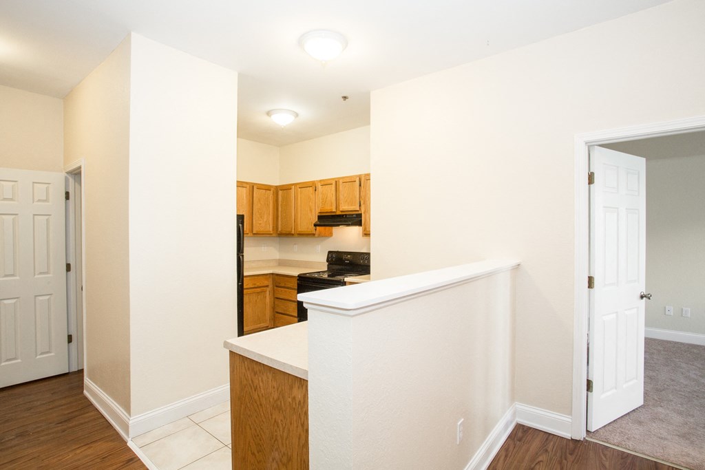 the view of a kitchen and living room with an open door