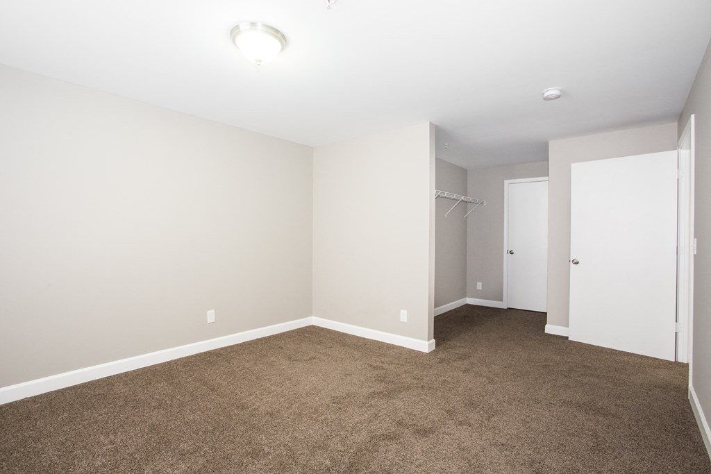 an empty room with carpet and a closet