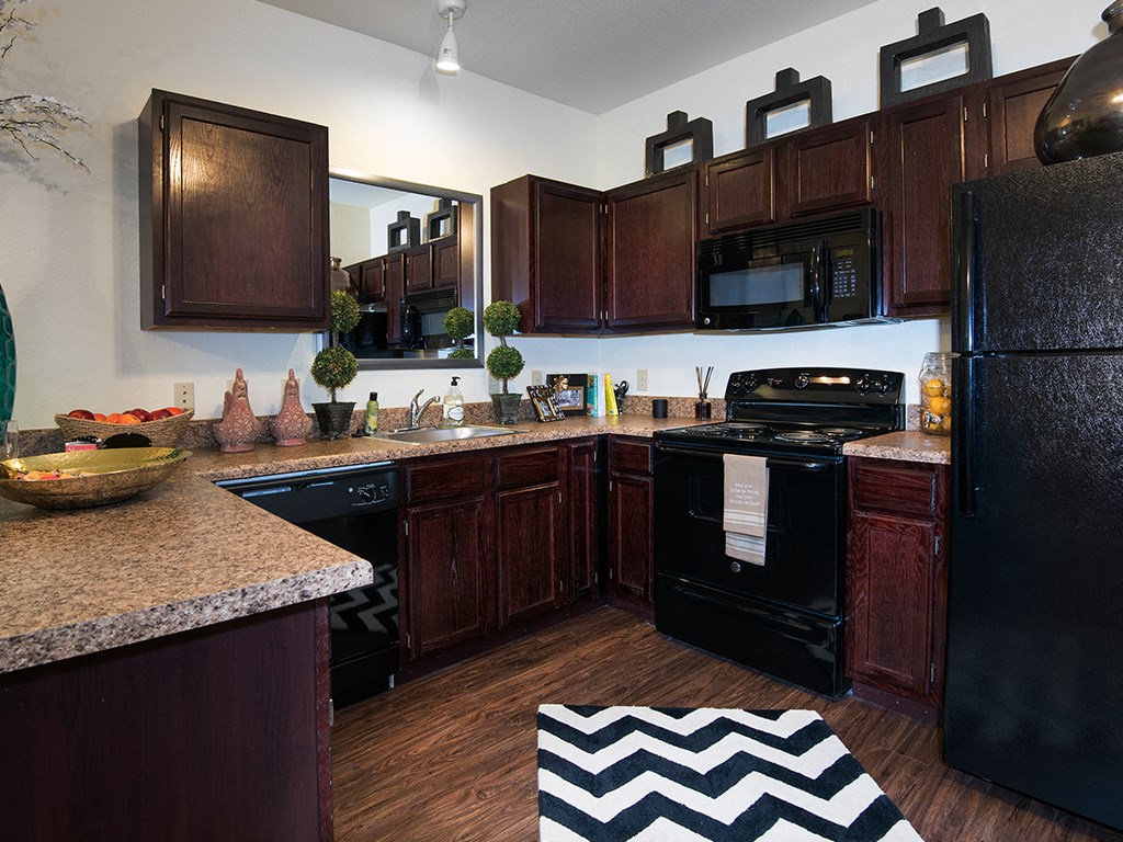 a kitchen with dark wood cabinets and black appliances
