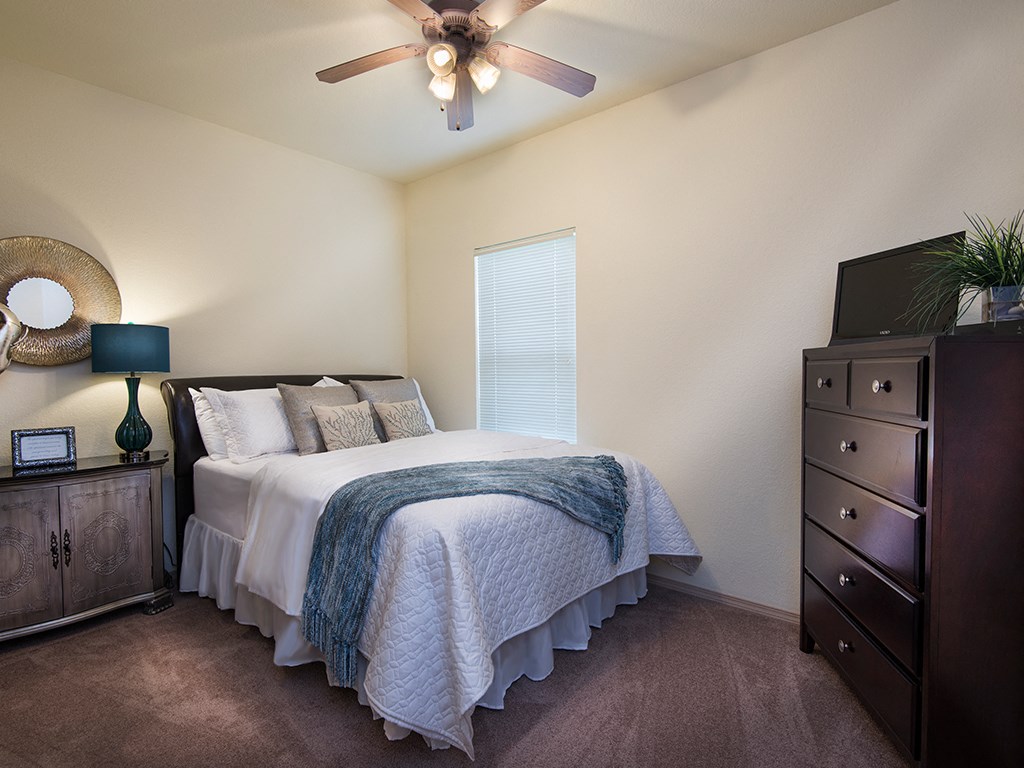 a bedroom with a bed and a ceiling fan