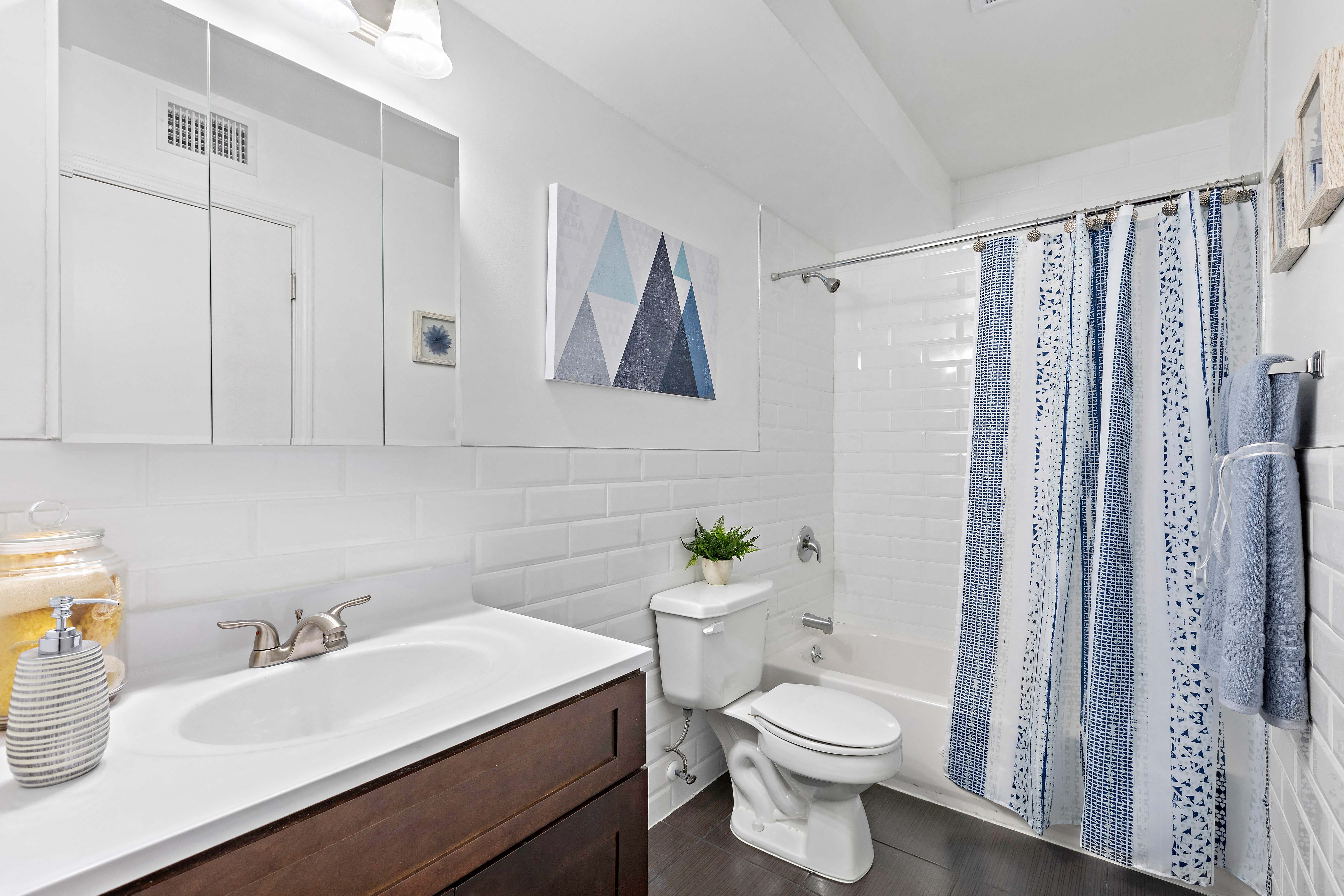 a white bathroom with a blue and white shower curtain