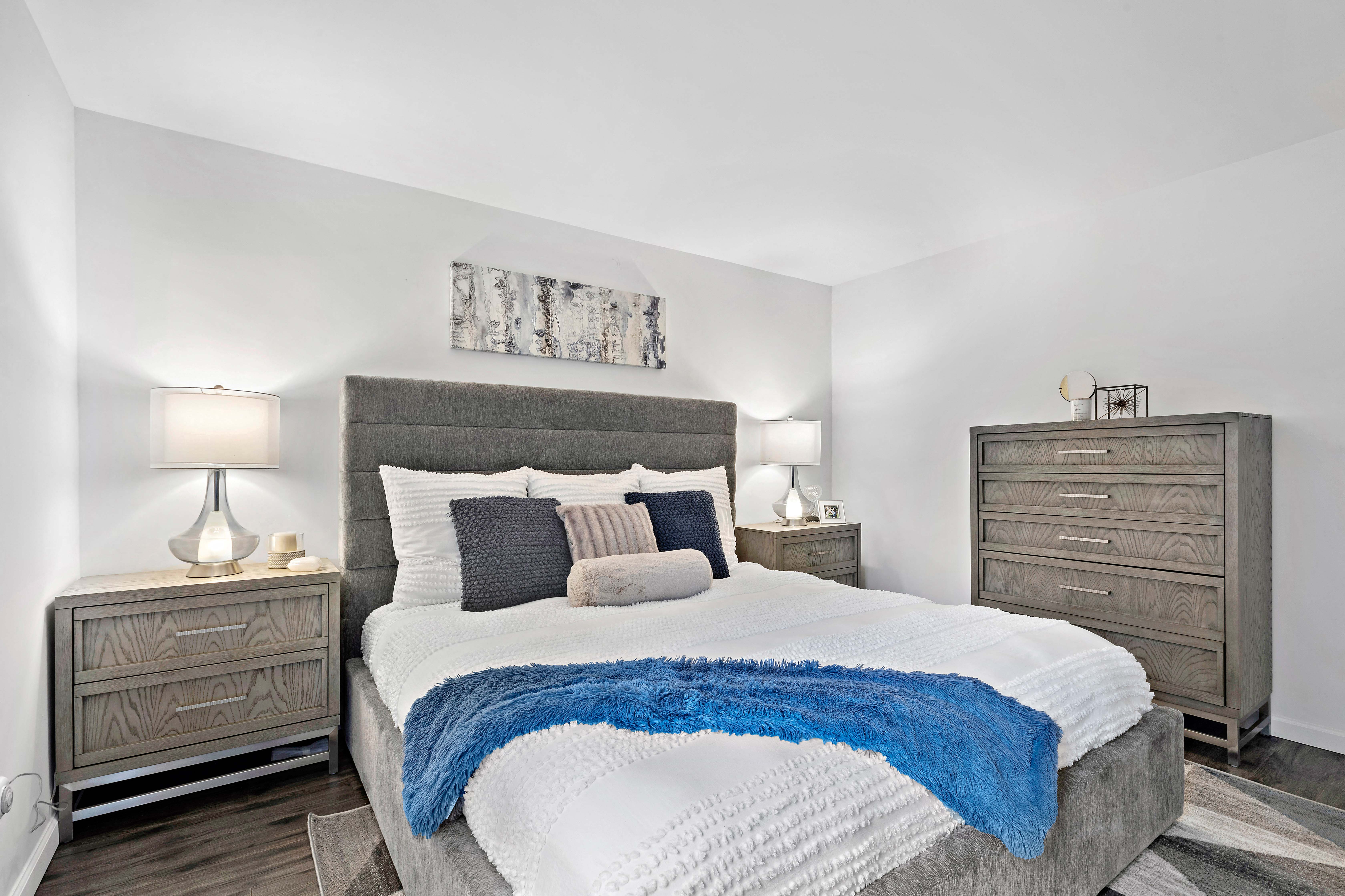 a bedroom with a bed and two dressers