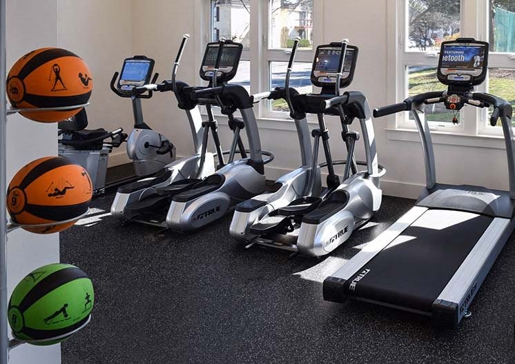 a group of exercise machines in a room with a ball