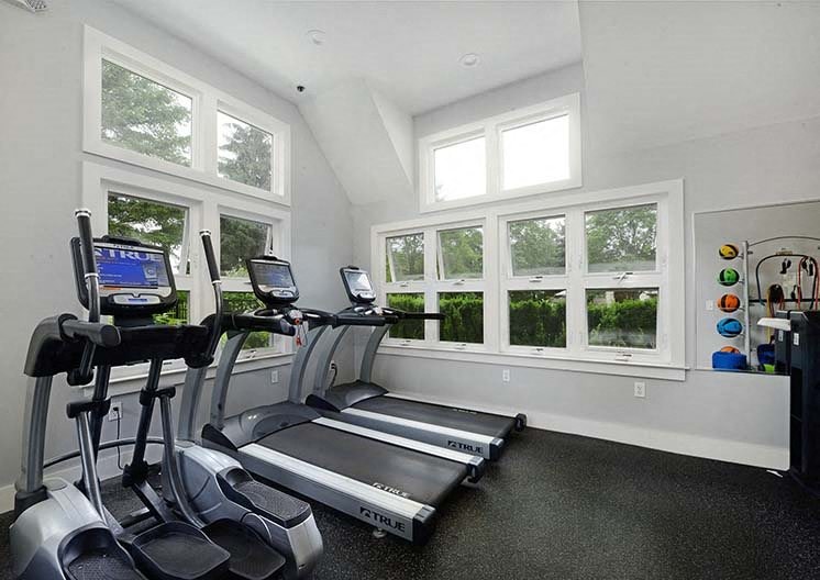 a workout room with exercise equipment and windows