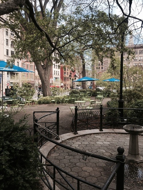 a park with benches and trees and buildings