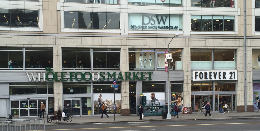 the facade of a building with people walking in front of it