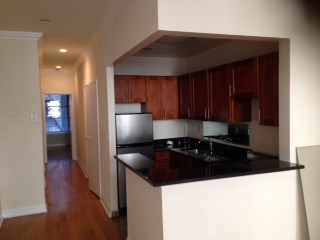 an empty kitchen with a black counter top