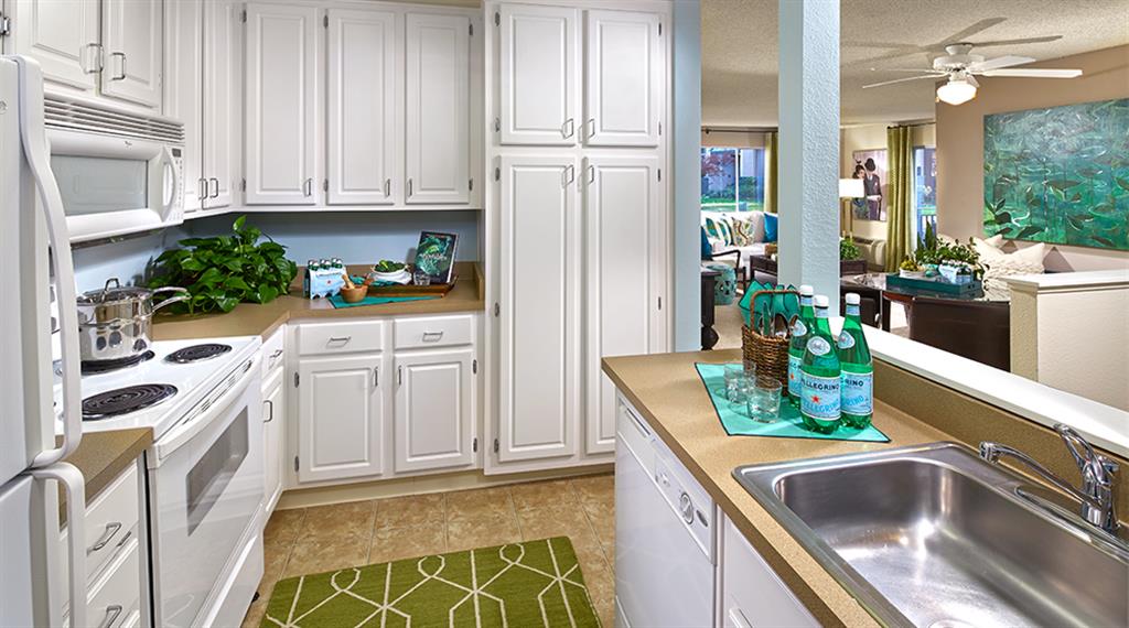 Whirlpool kitchen appliances, white raised panel cabinetry, full-sized washer/dryer