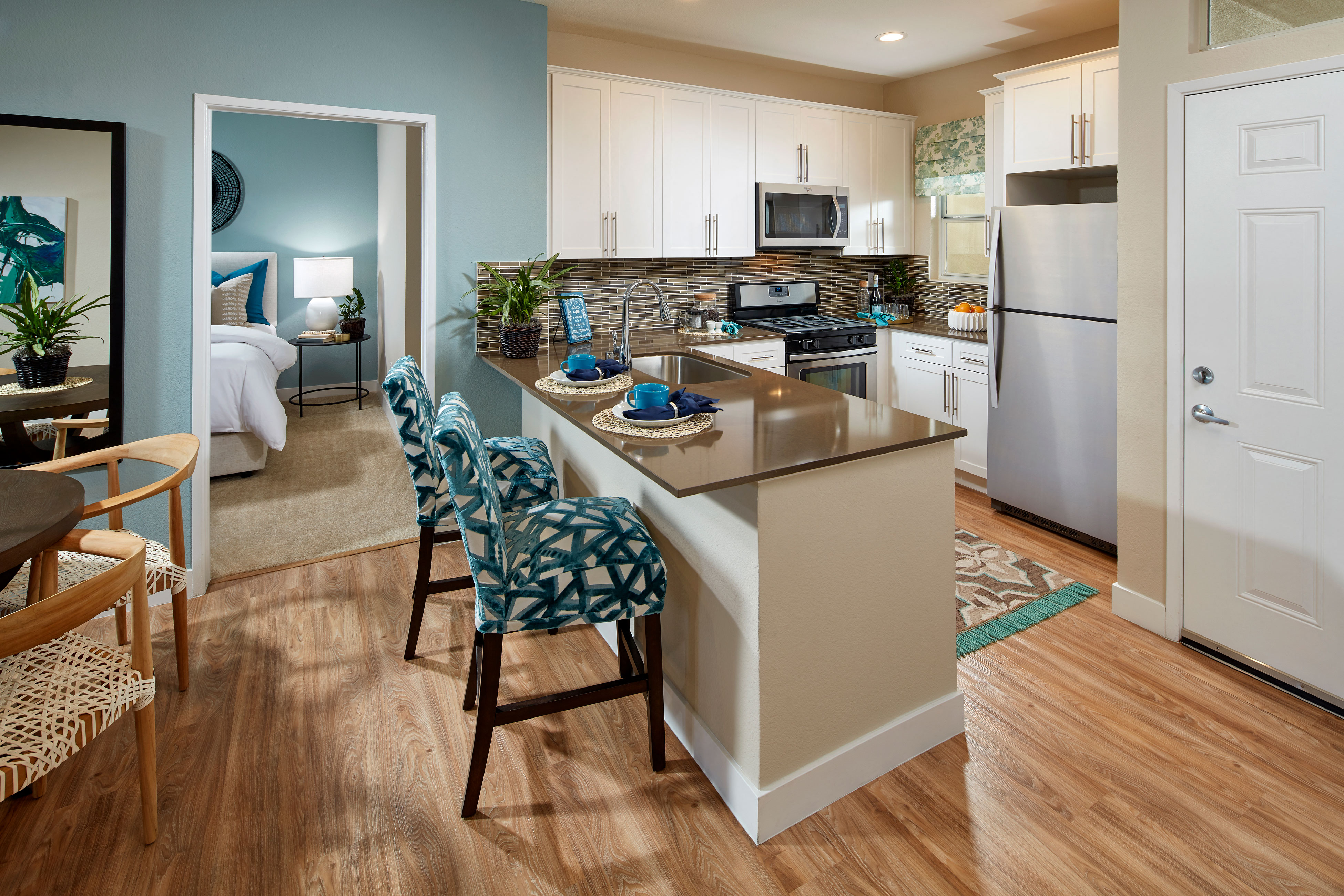 white shaker cabinetry, quartz countertops, contemporary backsplash and stainless steel appliances