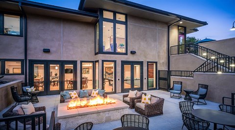 a living room with a fire pit and patio furniture