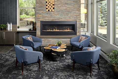 a living room with blue chairs and a fireplace