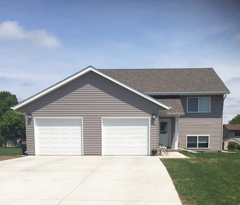 a house with two garage doors on the side of a driveway
