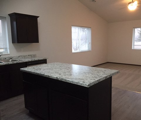 an empty kitchen with a granite counter top