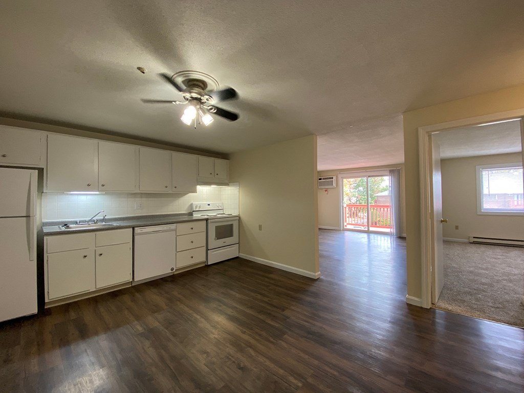 A kitchen with white cabinets and a ceiling fan.