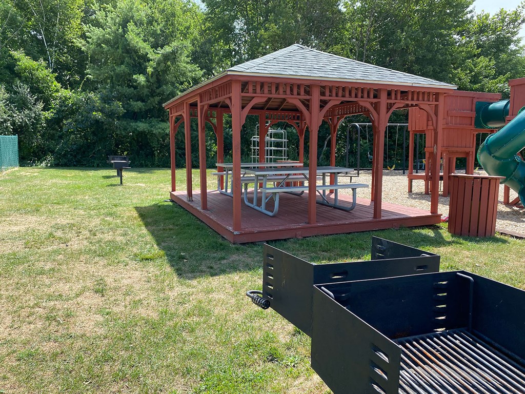 A gazebo is surrounded by a green lawn.