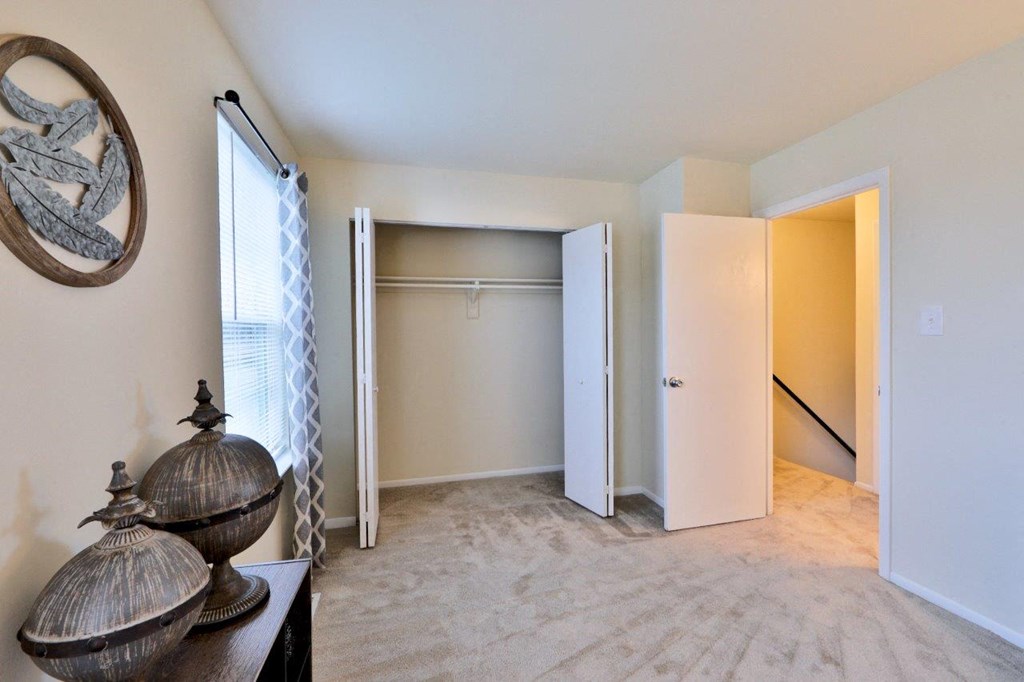 an empty living room with a closet and a window