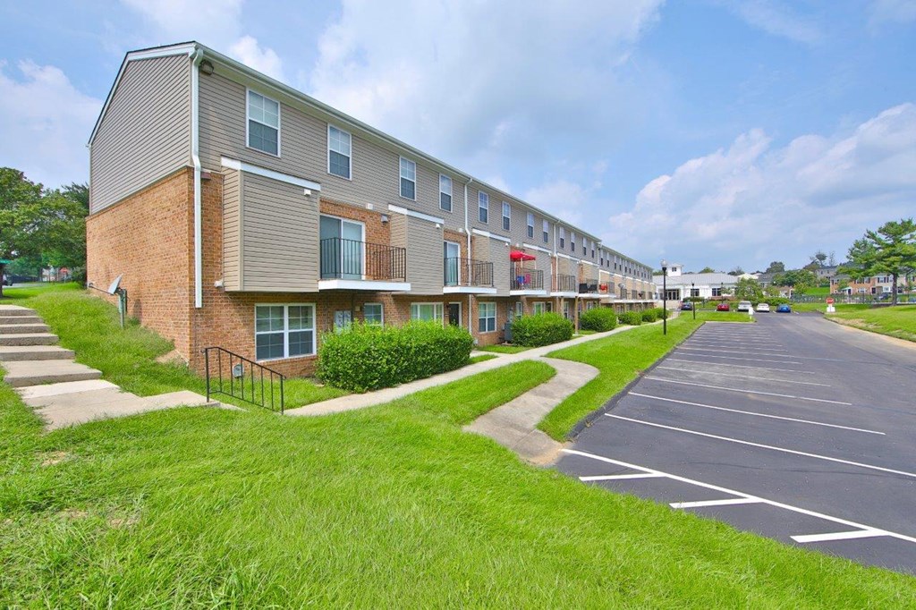 an empty parking lot in front of an apartment building