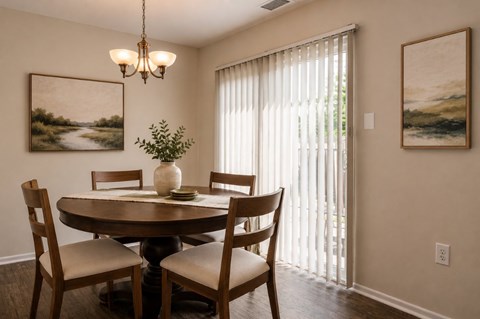A dining room with a table set for two and a plant on the table.
