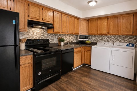 A kitchen with black appliances and wooden cabinets.