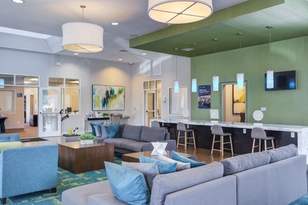 a living room with couches and chairs and a bar