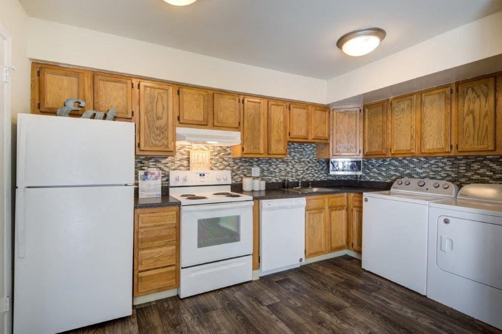 a kitchen with white appliances and wooden cabinets