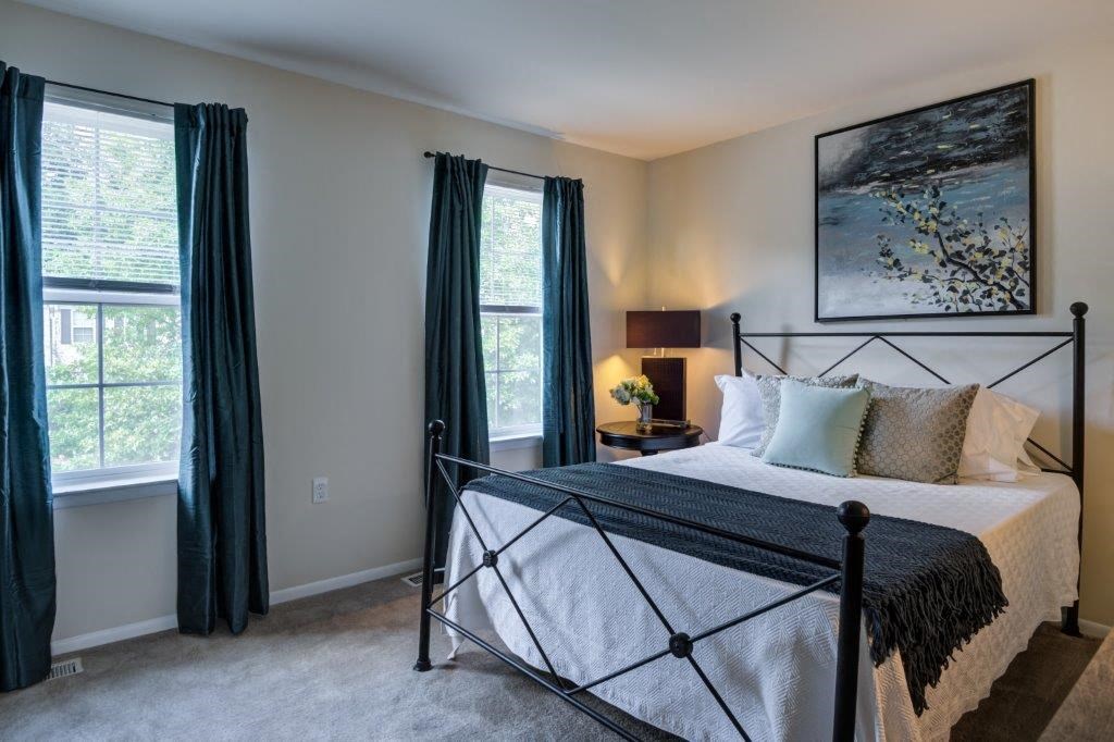 a bedroom with a bed and two windows