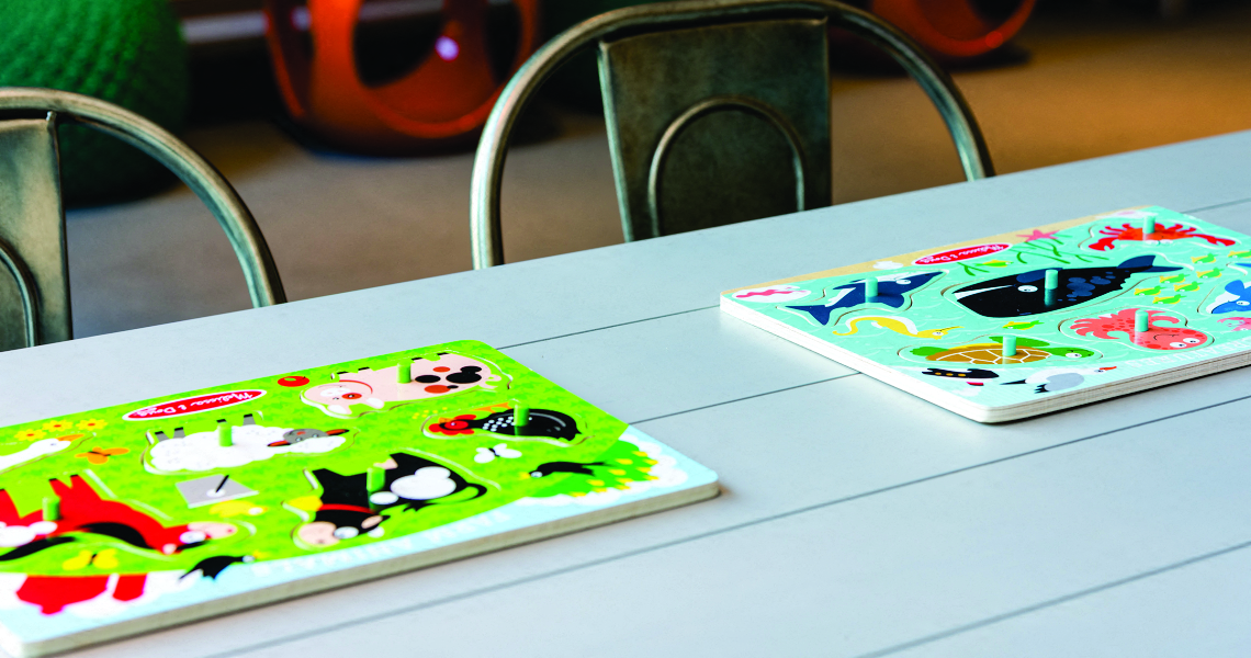 children's puzzles on playroom table at Tower 28, Long Island City, NY
