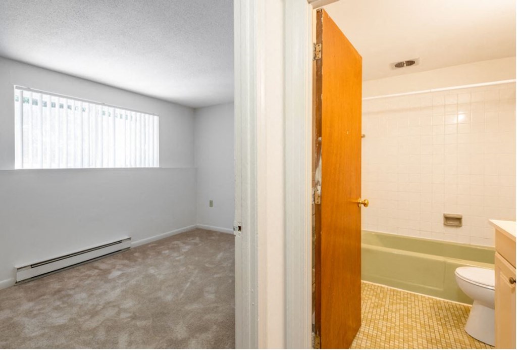 an empty bathroom with a toilet and a bath tub