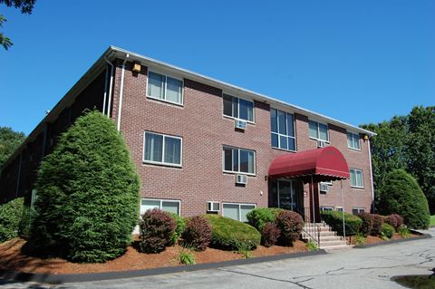 a brick apartment building with a red awning