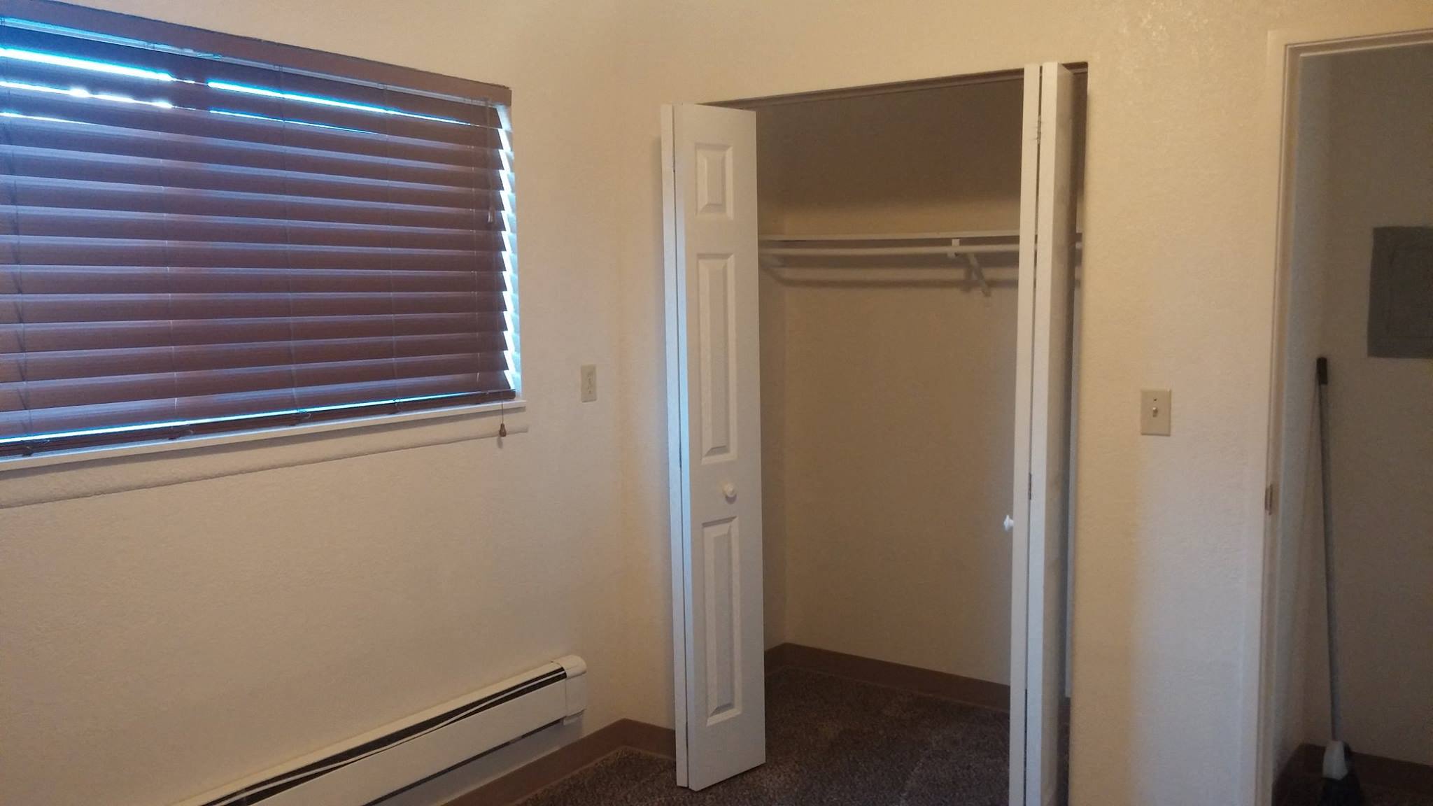 a room with a window and a closet and a door