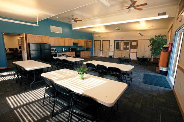 a dining room with tables and chairs and a kitchen