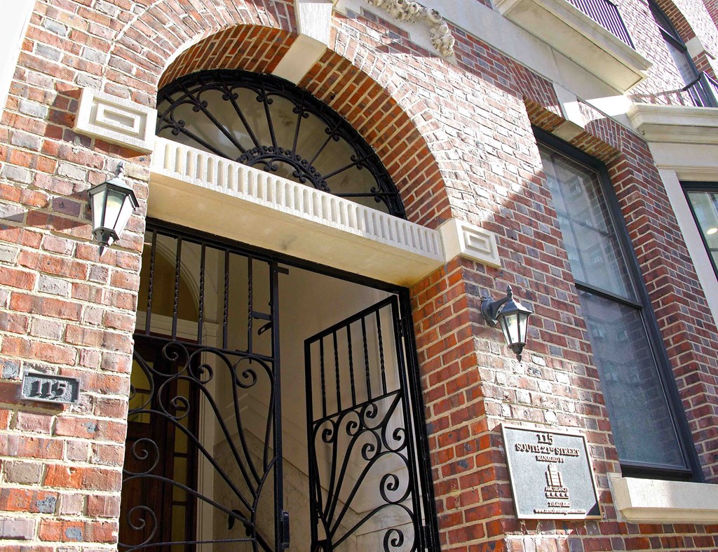 the front door of a brick building with a wrought iron gate
