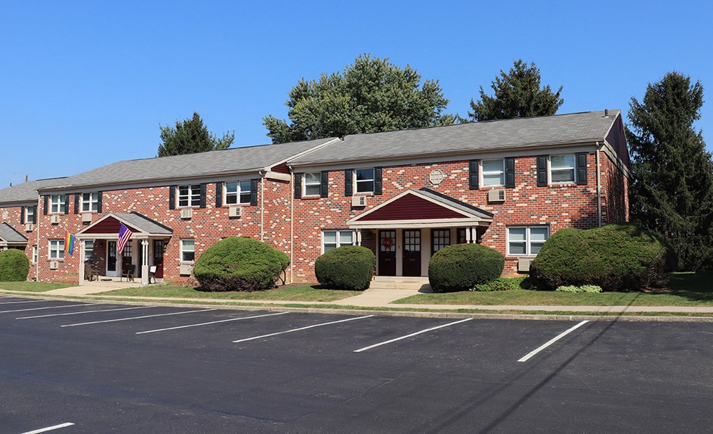 a red brick apartment building with a parking lot