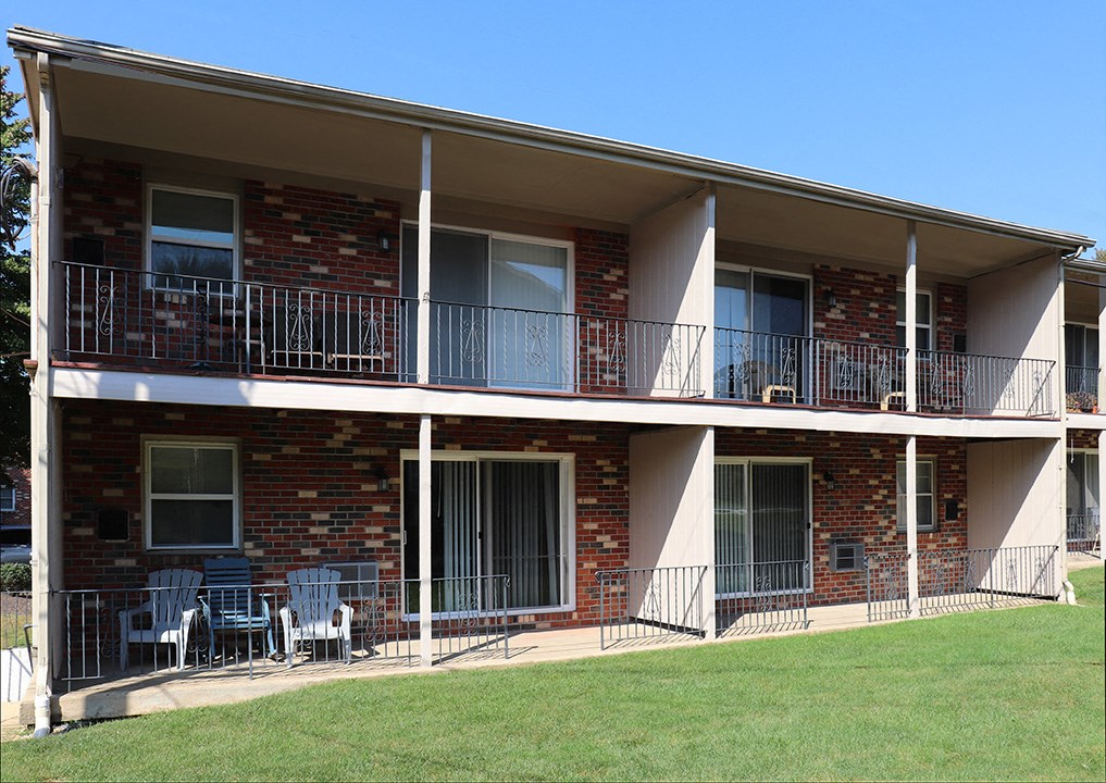 an apartment building with two balconies and chairs on the porch
