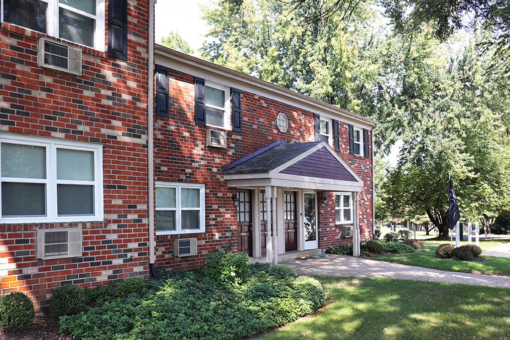 the front of a brick house with a porch