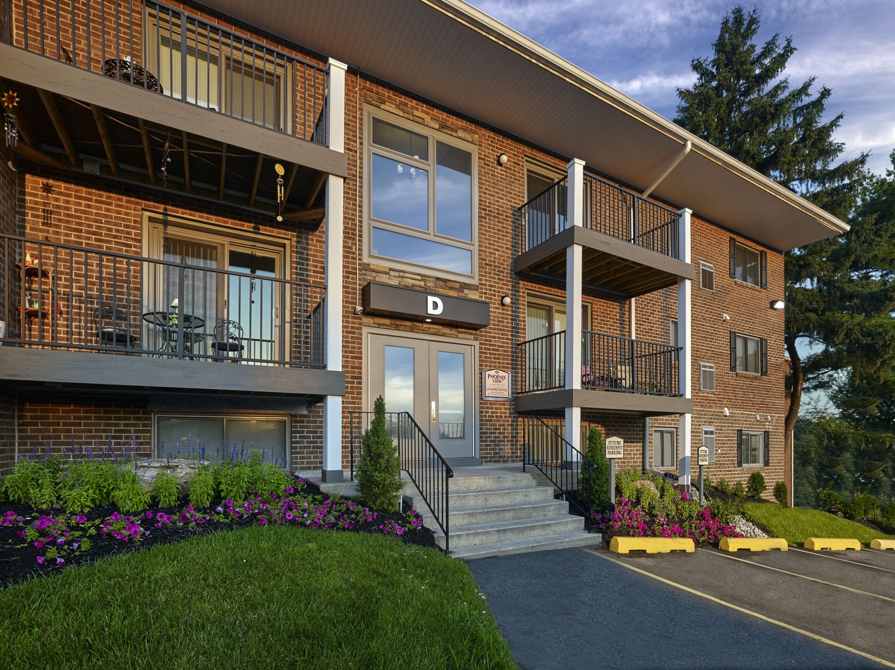 a view of the front of a brick building with stairs and a sidewalk