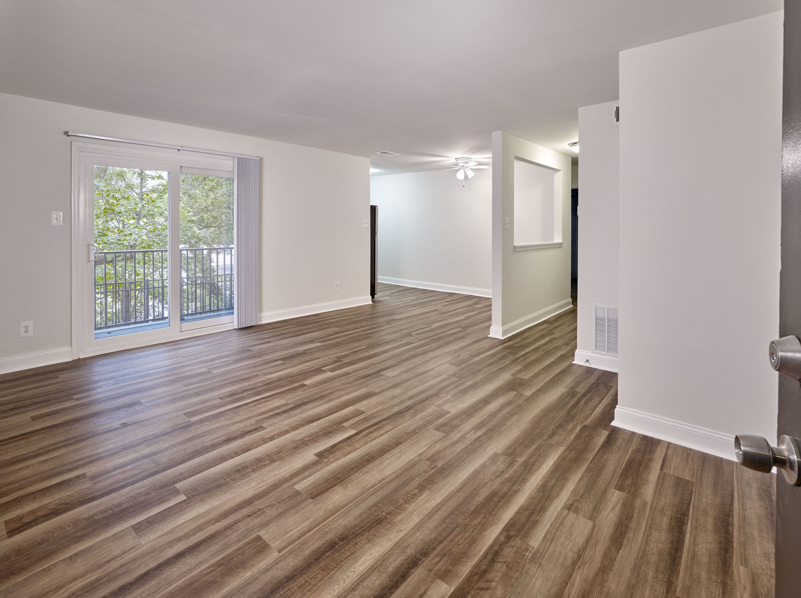 the living room and dining room of an empty house with wood flooring
