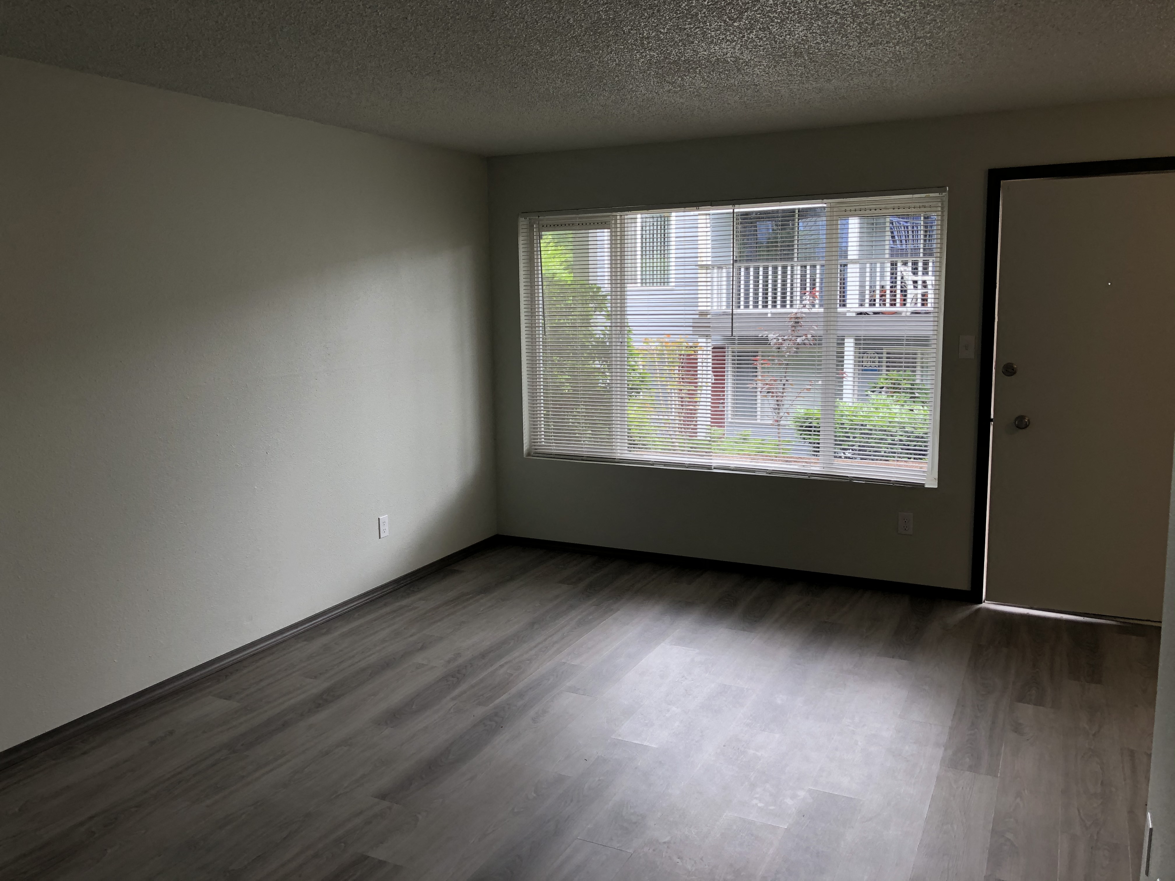 A room with a view of a balcony through the window.