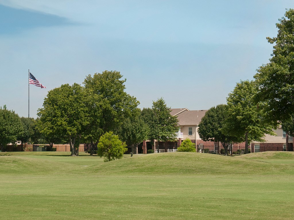 a large lawn in front of a building with an flag