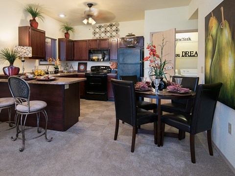 a dining room and kitchen with a table and chairs and a refrigerator