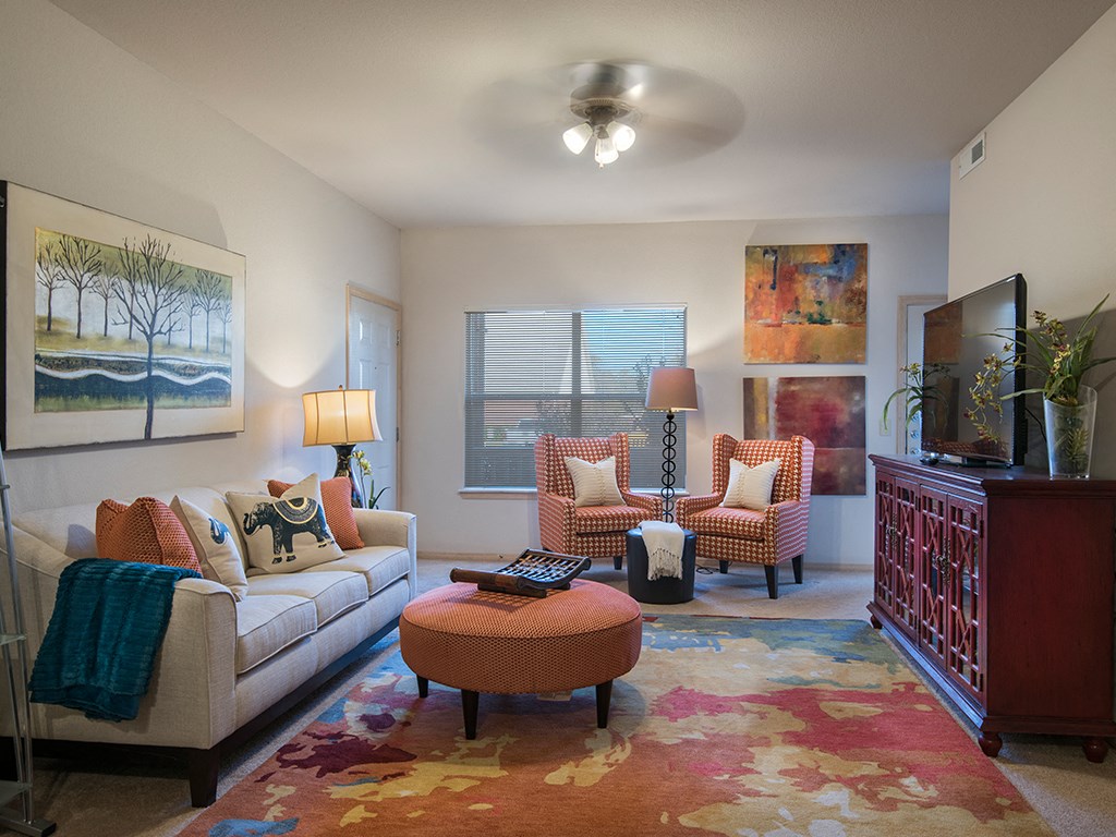 a living room with a couch and chairs and a tv