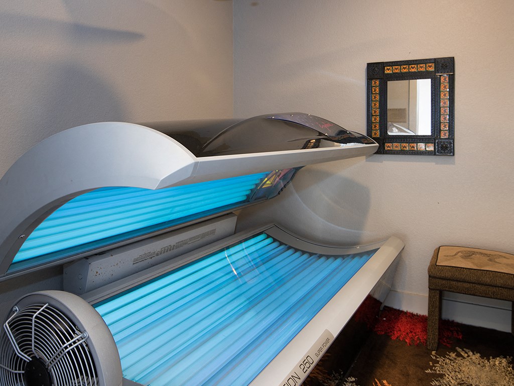 a small room with a bed and a air conditioner