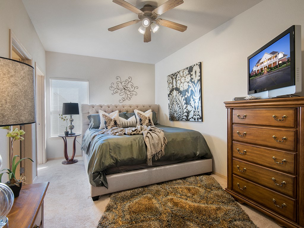 a bedroom with a bed and a ceiling fan