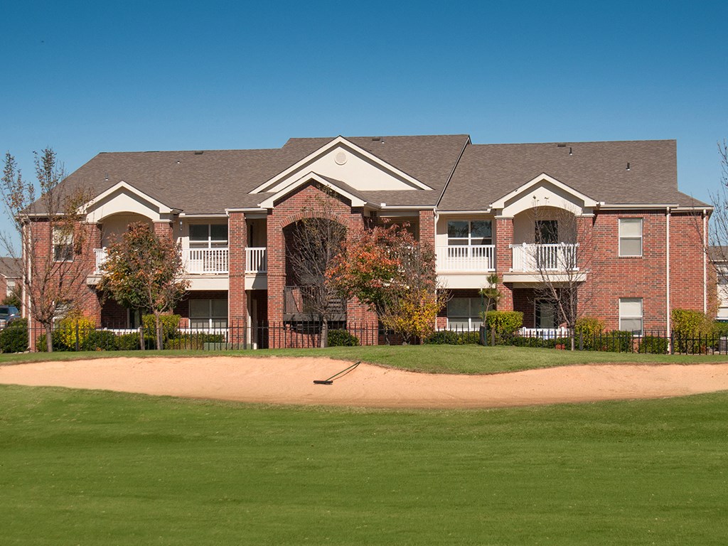 an apartment building with a baseball field in front of it