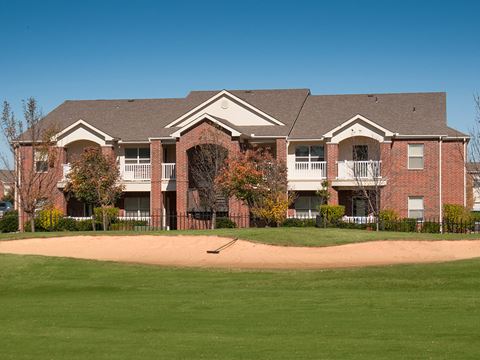 an apartment building with a baseball field in front of it