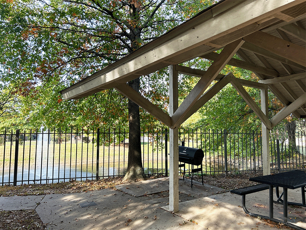 a picnic table and a grill in a park