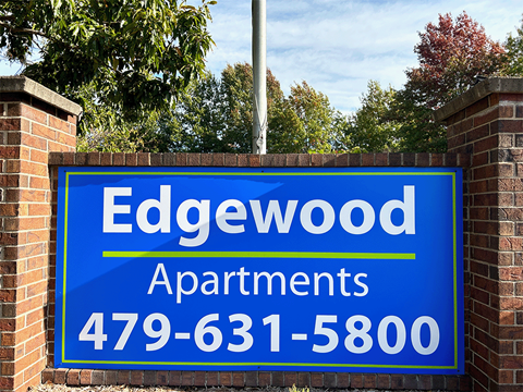 a sign for edgewood apartments is displayed on a brick wall
