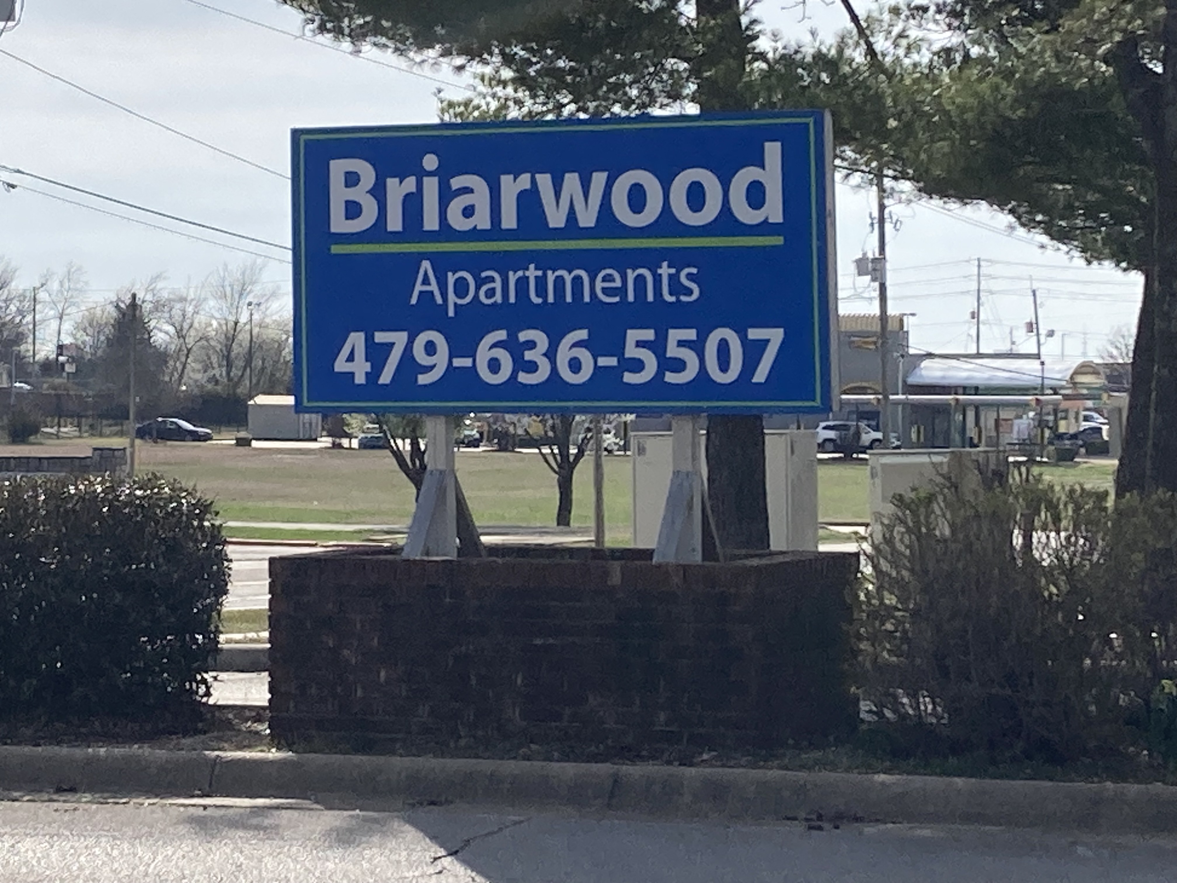a sign for birrwood apartments on the side of the road