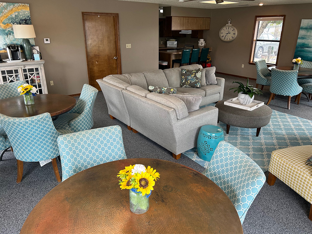 a living room with a couch and chairs and a table with flowers