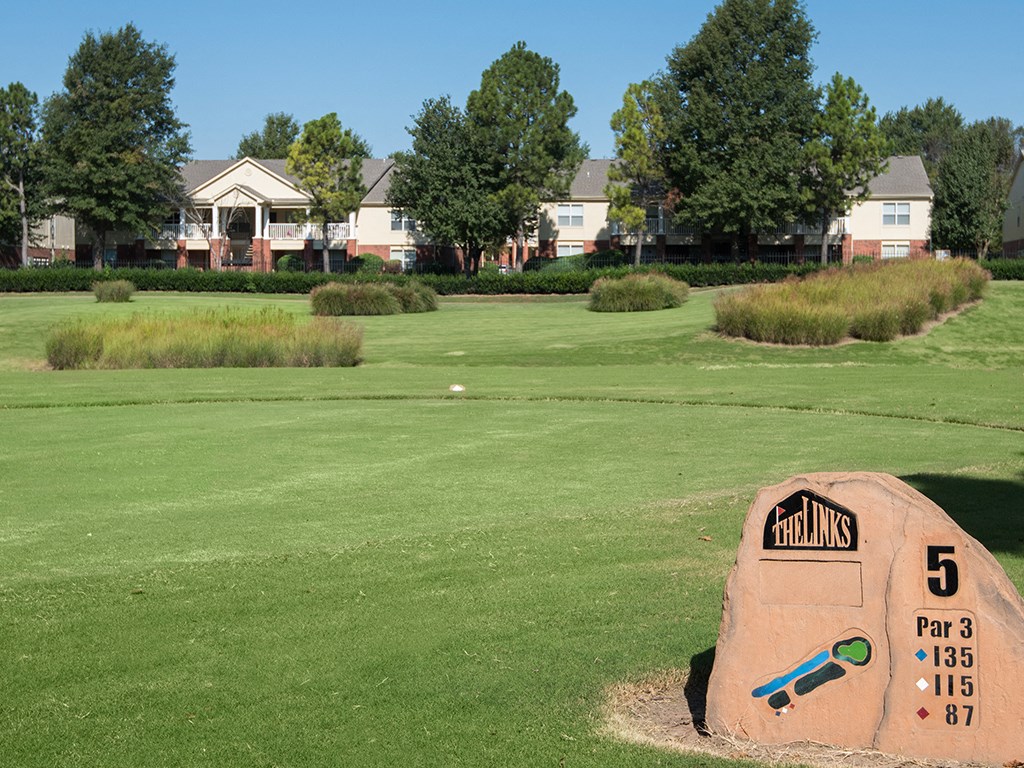 a golf course with houses in the background